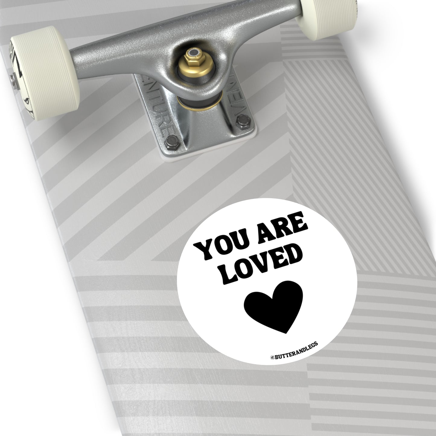 WHITE STICKER WITH BLACK TEXT THAT READS "YOU ARE LOVED" WITH A HEART