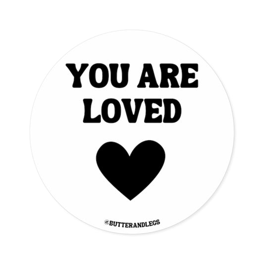 WHITE STICKER WITH BLACK TEXT THAT READS "YOU ARE LOVED" WITH A HEART