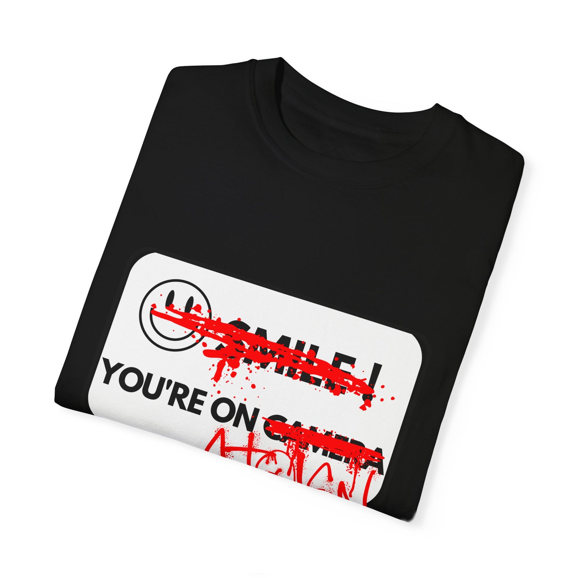 A BLACK T-SHIRT FEATURING A WHITE "SMILE YOU'RE ON CAMERA" SIGN WHERE THE SMILEY FACE AND WORDS "SMILE" AND "CAMERA" HAVE BEEN GRAFFITIED OUT WITH RED SPRAY PAINT AND THE WORDS "STOLEN LAND" HAVE BEEN ADDED AFTER "YOU'RE ON" IN RED SPRAY PAINT