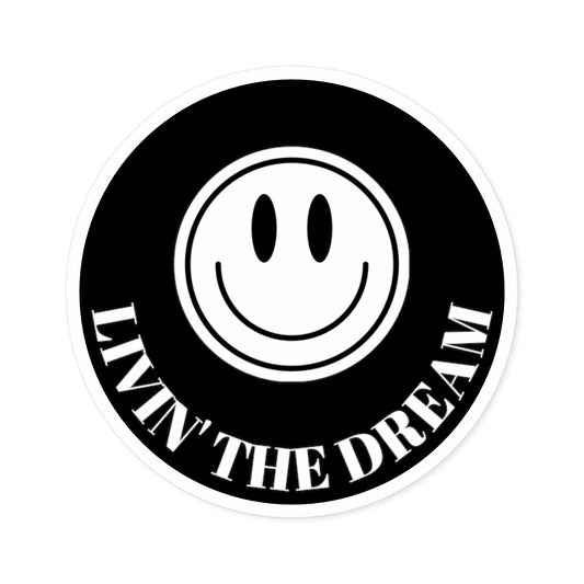 BLACK STICKER WITH A WHITE AND BLACK SMILEY FACE AND WHITE TEXT THAT READS "LIVIN' THE DREAM"